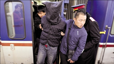 犯罪嫌疑人被便衣押下火车。本报记者 董世彪 摄